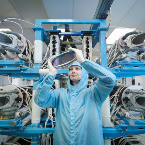 a man in a blue coat is standing in front of a machine.